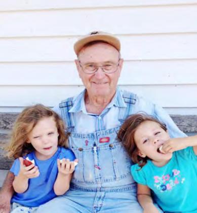 Bob Blecha in overalls with his grandchildren.