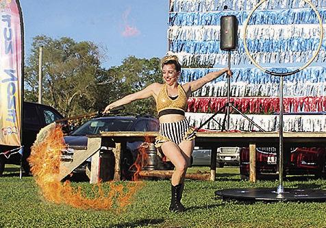 A fire dancer twirls her baton during a performance in the Fun Zone Photo by Reagan Connelly