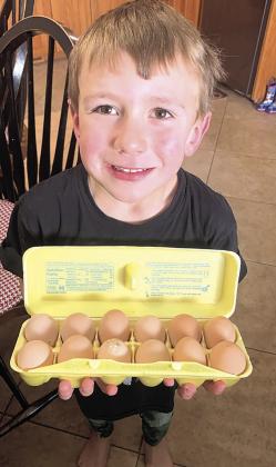 Above: Blane Vogt, age 5, with some of his Tall Corn Acres eggs
