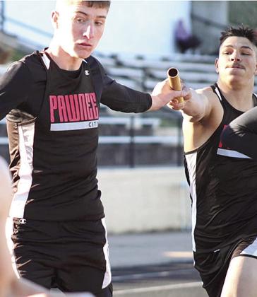 P.C.’s Drew Menninga (left) takes the baton from teammate Trey Kling (right) in the boys’ 1600 M. relay. Photo courtesy of Jamie Maloley