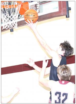 P.C.’s Bryce Gyhra lays up a shot on the baseline as LHS’ Ty Arena (#32) defends. Paula Jasa/Republican