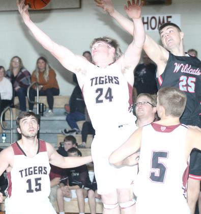 LHS’ Tristen Ray (#24, center) goes up for a rebound against Cedar Bluffs on Friday night while teammates Brady Bledsaw (#15, left); Everett Bohling (#5, right) look on. The Tigers won their third straight game of the week against Cedar Bluffs, 63-15. Paula Jasa/Republican