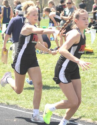 P.C.’s Madelyn Osborne (left) hands off to Emily Lytle (right) in the last leg of the 3200 M. relay event. Paula Jasa/Republican
