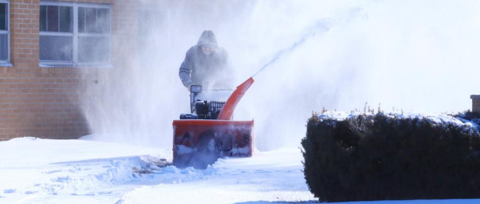 Keith Groeling clears the walks at Faith Baptist Church Sunday. Ray Kappel/Republican