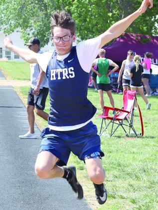HTRS’ Kiffen Hunzeker (above) soars in the boys’ Long Jump event while LHS’ Justice Currie (right) gets some extra distance in the Triple Jump. Hunzeker placed 2nd in the Long Jump at 18’11 1/2” to qualify for the State Track Meet. Jasa/Republican