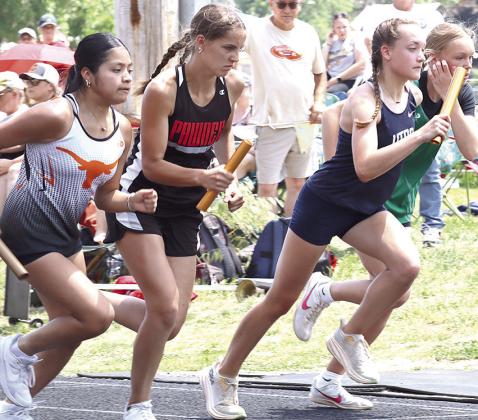 HTRS’ Grayson Sherman (right) and Pawnee City’s Emalyse Gottula (left, center) are determined in their first legs of the girls’ 3200 M. Relay.