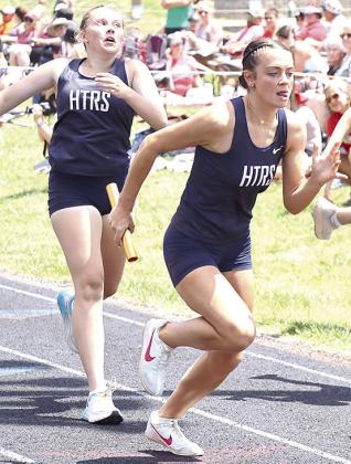 HTRS’ Lillian Bowen receives the baton from teammate Eden Duryea and goes for gold in the 3200 M. event. The Lady Titans were clocked at 10:21.75.