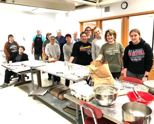 From the 2016 bake, continuing the first lesson: Brittany Freeman and Paige Rogge watch mentor Barb Harris check the consistency of the dough. In the background, Elma Lee Buchholz chats with Jan Krofta, and Glenda Blecha.