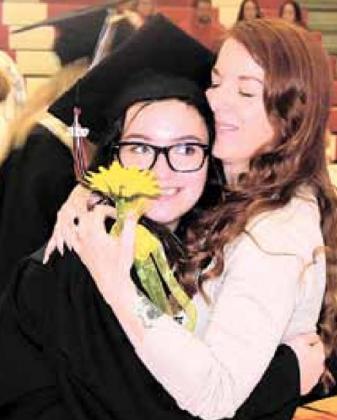 Graduating senior Rachael Ray hugs mom Heather Ray and gives her a sunflower, the class flower. Ray Kappel/Republican