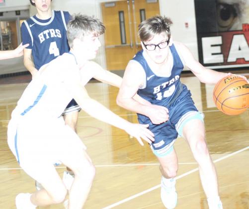 HTRS’ Gage Schaardt (#14, right) brings the ball down the floor against NCL in the Class D1-1 boys’ subdistrict finals on Thursday night. Schaardt hit six treys in the game and led the Titans with 20 points. Also pictured is teammate Nic Knudson (#4). Paula Jasa/Republican