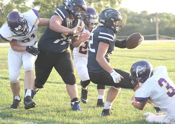 HTRS’ Hunter Bohling (#22, center) spins for more yardage against Deshler as teammate, Ryken Davis (#72, left) looks to help out. Paula Jasa/Republican
