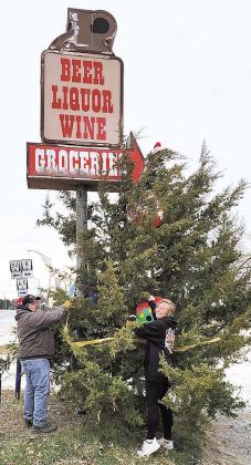 Jamie Kramer and Angie Hunt started to work on Christmas decorations at the Little Brown Jug in Pawnee City. They invite people to help decorate the huge tree they have set up under the sign for the Brown Jug.