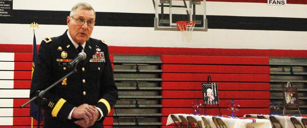Photos submitted by Anne Veleba The guest speaker for the day was Ret. Major General Charles 'Jim' Barr from the US Army. In the background you can see tables set up for the luncheon that was prepared by Karen Blank and the kitchen staff and was served by Student Council members. Displayed on the easels are posters created by Mrs. Pierce's fifth grade class, paying tribute to friends and family members who have served in various branches of the military.