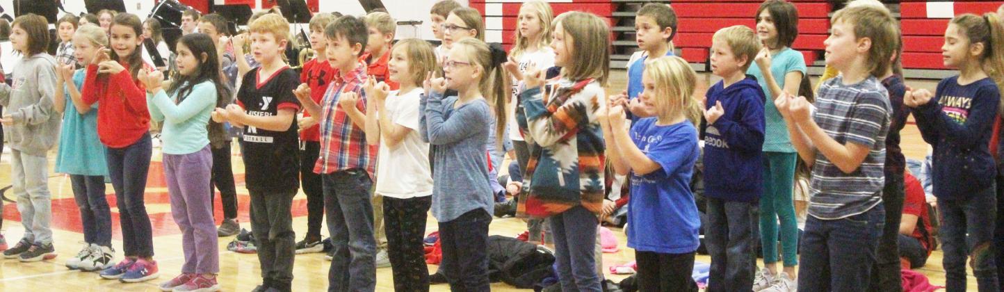 2nd and 3rd graders start the program with 'I Love My Country,' a song with sign language.