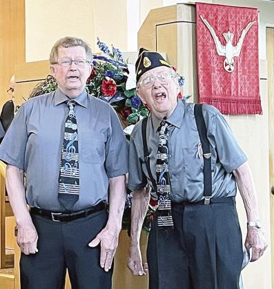 Gary Lesoing of Auburn, left,and World War II veteran Kenneth Eichenberger, Sr., right, sang with a group from the Homestead Harmonizers,