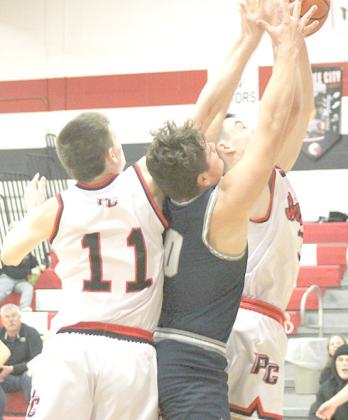 P.C.’s Brysen Horst (#11, left), HTRS’ Hunter Bohling (#0, center) and P.C.’s Jett Farwell (right) battle under the boards for a rebound at the Pioneer Tourney. Paula Jasa/Republican
