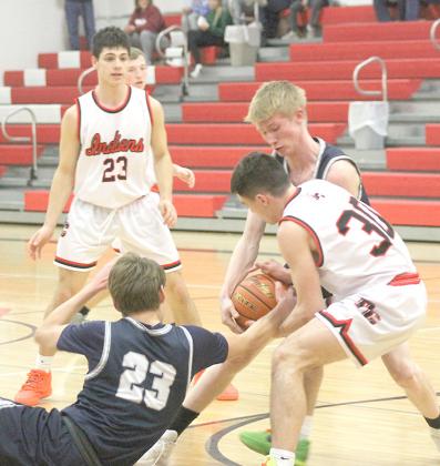 HTRS’ Brandt Leech (#23 on floor) reaches for a loose ball against P.C.’s Jett Farwell (#30, right) and Titan teammate Brogan Dunlap (right) as P.C.’s Anthony Kling (#23, left) looks on. Pawnee City and HTRS battled it out at the Pioneer Conference last Monday night with P.C. claiming the 54-41 victory. Paula Jasa/Republican