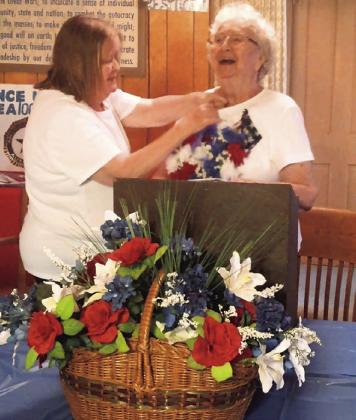 Glee Price stays true to her name as she tips her head back in laughter while recieving a large heart-shaped floral pin for 20 years of service as president of unit 168