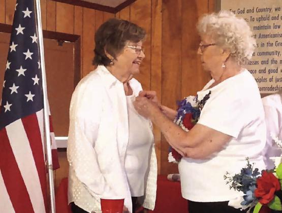 A Unit 168 member smiles widely as she receives a service pin