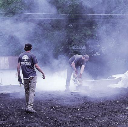 Garett Crist (right) and Thomas Heinz (left) of Creative Landscaping construct a retaining wall for Tranquility Park Photo by Reagan Connelly