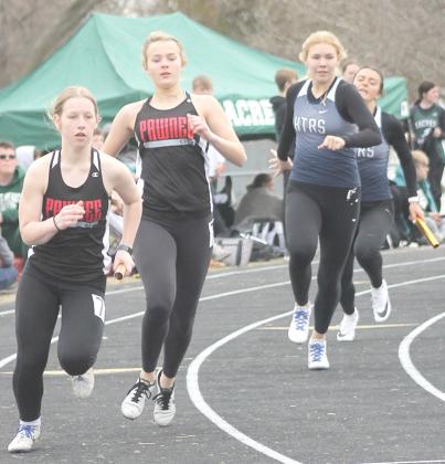Paula Jasa/Republican P.C.’s Cara Pierce (left) takes the baton from teammate Anna Meints while HTRS’ Elie Bstandig (right) gets her relay from Lady Titan teammate Lillian Bowen in the girls’ 400 M. Relay event at the JCC Invitational.