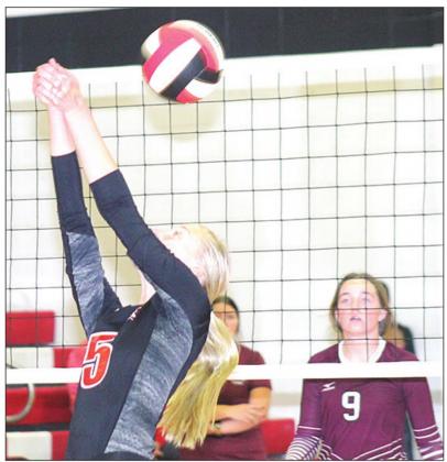 P.C’s Sierra deKoning (#5, left) takes a free ball over the net as LHS’ Carleigh Weyers (#9, right) looks on. Paula Jasa/Republican