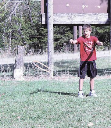 Student Micah watches the followthrough of his hoop toss during a lesson on how to play the game, taught by Carol Sisco