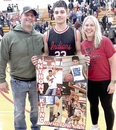 P.C.’s Anthony Kling (center) pictured with Shane and Jamie Maloley, proudly displays his poster of achieving 1,000 career points for the Pawnee City Indians after their game against Johnson-Brock last week. Photo provided
