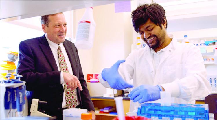 Eric Weaver, director of the Nebraska Center for Virology, consults with Zahidul Islam, who recently joined the Weaver laboratory as a graduate student. Weaver led a study whose newly published findings reveal a breakthrough on flu vaccines for swine, birds and humans. (Courtesy of the University of Nebraska-Lincoln)