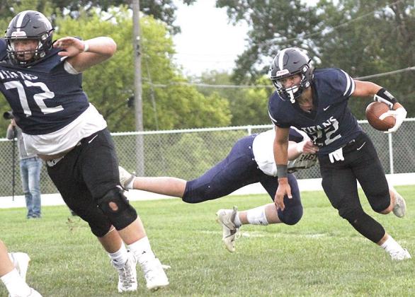 HTRS’ Hunter Bohling (#22, right) eludes a tackler in the backfield as teammate Jake Davis (#72, left) blocks out in front. Bohling rushed 25 times for 275 total yards and accounted for six of the Titans’ seven touchdowns in the 52-38 win over OCA. Paula Jasa/Republican