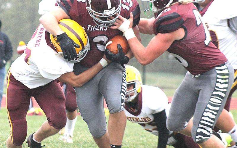 Lewiston’s Brady Bledsaw (#13, center) surges forward for extra yardage as teammate Tristen Ray (#25, right) tries to help out in the Tigers’ Homecoming game. Paula Jasa/Republican