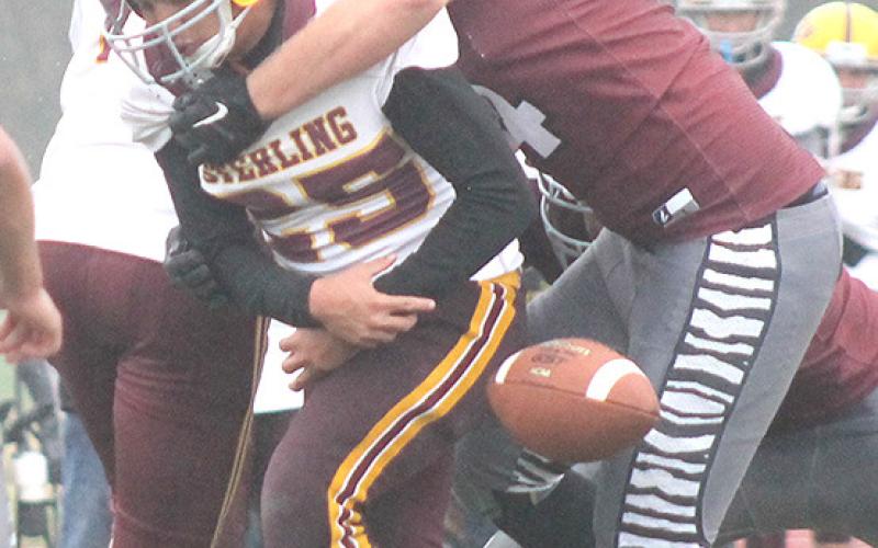 LHS’ Caleb Rule (#14, right) forces a fumble against Sterling early in the game.