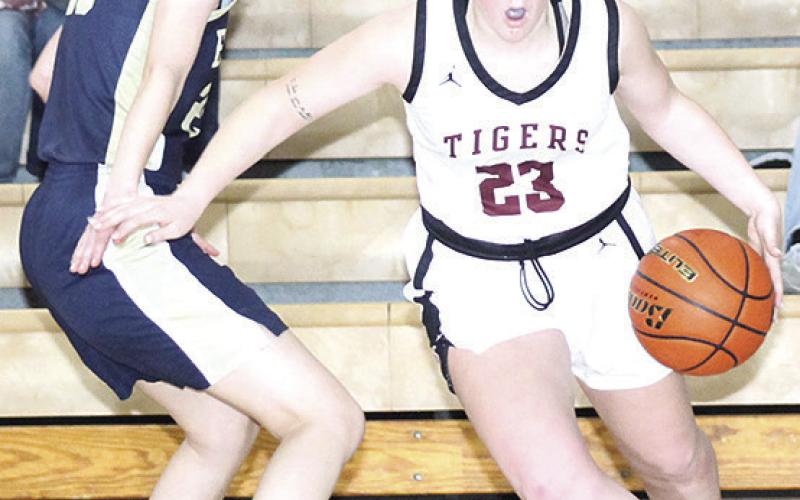 LHS’ DeLanye Currie (#23, right) drives past an OCA defender on the baseline on Saturday. Currie led the Lady Tigers with 9 points in LHS’ 37-35 Saturday win. Paula Jasa/Republican