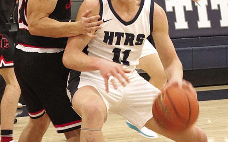 HTRS’ Emmett Glathar (#11) drives the lane against P.C.’s Anthony Kling (left) in Tuesday night’s game. Paula Jasa/Republican