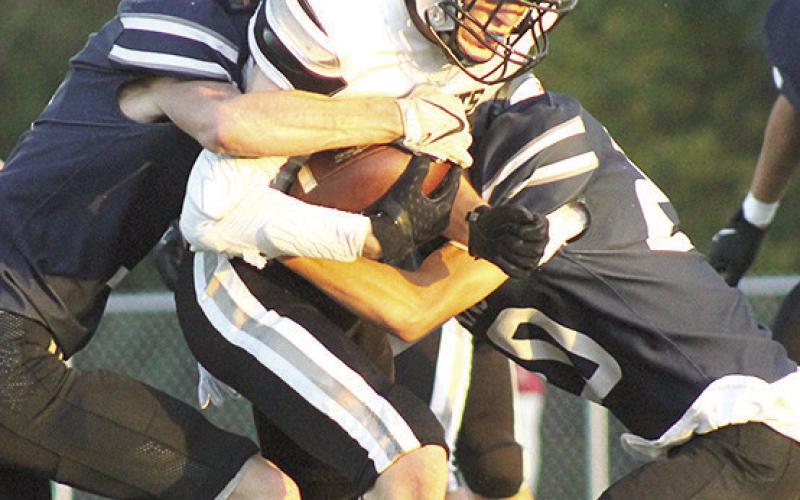 HTRS’ Brogan Dunlap (left) and Axton Wamsley (#20, right) bring down an Elmwood-Murdock runner. Paula Jasa/Republican