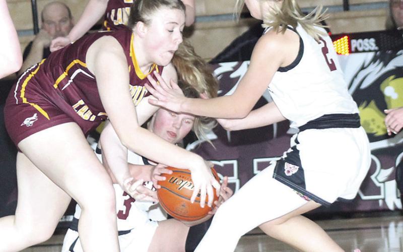 LHS’ Ayden Hunzeker (#3, center) fights for a loose ball as teammate Justice Currie (#2, right) looks to help out against Sterling.