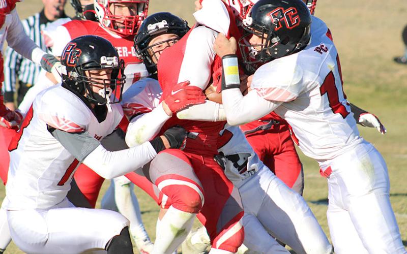 P.C.’s Hunter Johnson (left), Andy Maloley (center) and Anthony Kling (right) sandwich a Potter-Dix player in an Indian gang tackle on Friday afternoon. photo courtesy of Jamie Maloley