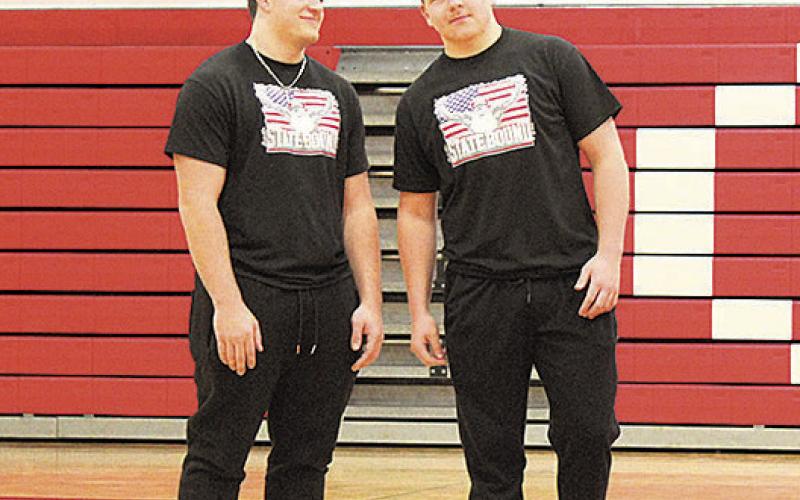 Dylan Layne (left) and Gauge Schuetz (right) receive applause from their school during a pep rally
