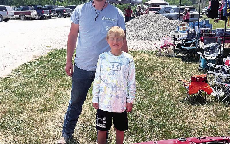 Kenneth Klepper stands with Alex Graf, winning his new kayak.