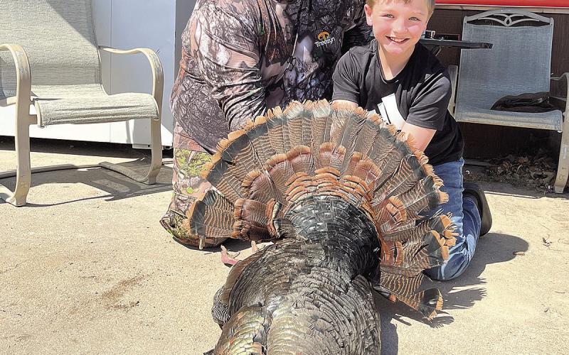 Mason Ellston (right) and his dad, Cole (left) pose with Mason’s turkey