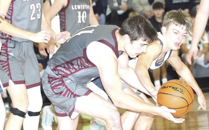 LHS’ Brady Bledsaw (#11, left) battles HTRS’ Brennen Vaughan (#2, right) for a loose ball during the Tigers vs. Titans game last Tuesday. Lewiston won 34-32. Paula Jasa/Republican