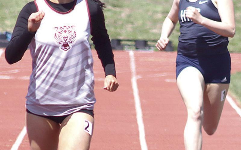 LHS’ Savannah Cutshall (left) finishes just ahead of HTRS’ Colby Hedden (right) in the girls’ 200 M. prelims. Paula Jasa/Republican