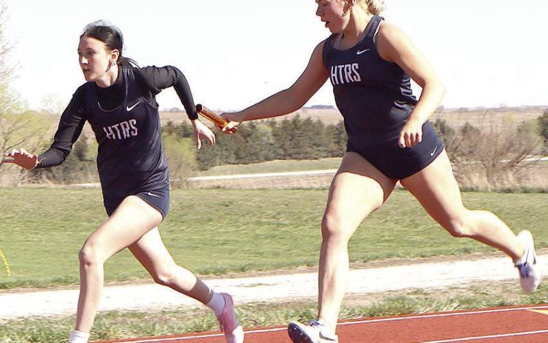 HTRS’ Elie Bstandig (right) hands off to teammate Harlee Hardesty (left) for the second leg of the girls’ 400 M. relay event. Paula Jasa/Republican