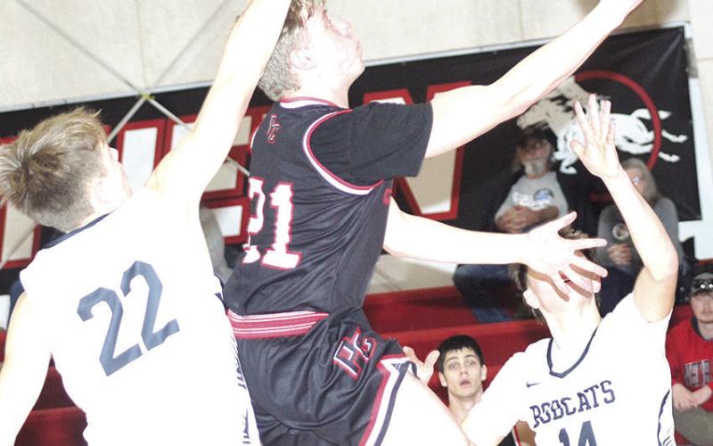 P.C.’s Trey Marteney drives to the hoop inbetween several E-M-F Bobcat defenders in Saturday’s 3rd place game at the Pioneer Conference Tournament. Paula Jasa/Republican