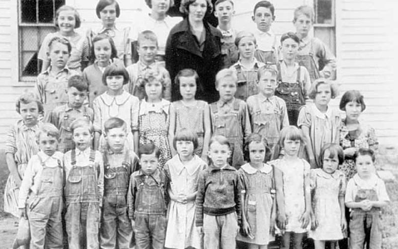 A traveling photographer took a school picture of the students on the front steps of the Maple Grove Country School. Bernice Marfice is the little girl in the front row, second from the right. The teacher was Marcella Klein Wheeler, then unmarried.