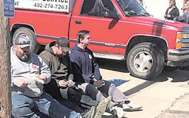 Volunteer fire fighters take a brief and much needed break. Items were taken all day Friday, and on Saturday the fire fighters stepped up to mark items, take bids, move the auctioneers trucks forward along the long line of sale items, and otherwise keep busy. Pictured are Travis Findlay, Bill Vogt and Joey Tyler. Sharla Sitzman Photos