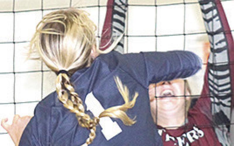 HTRS’ Laramie Glathar (#1, left) powers a spike past LHS’ DeLanye Currie (#7, right) last Tuesday. Paula Jasa/Republican