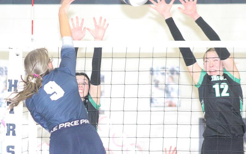 HTRS’ Avery Dierberger (#9, left) splits two FCSH defenders in the D2-1 subdistrict final match. Dierberger landed 20 kills against the Irish in the four set victory. Paula Jasa/Republican