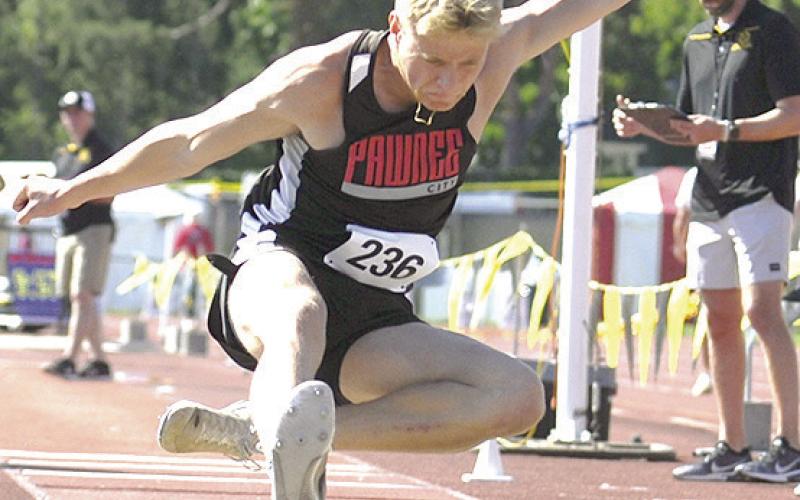 P.C.’s Trey Marteney goes in for a landing in the Class D boys’ Triple Jump event on Friday. Photo by Luke Nichols/Beatrice Daily Sun