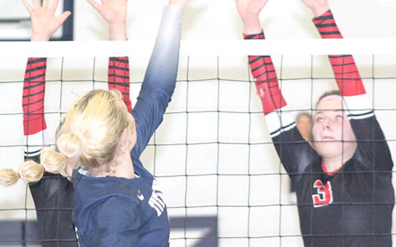 HTRS’ Elie Bstandig (center) goes up and over the Lady Mustang defense on Thursday. Bstandig had 13 kills, 2 solo ace blocks and 1 assisted block at the net. Paula Jasa/Republican